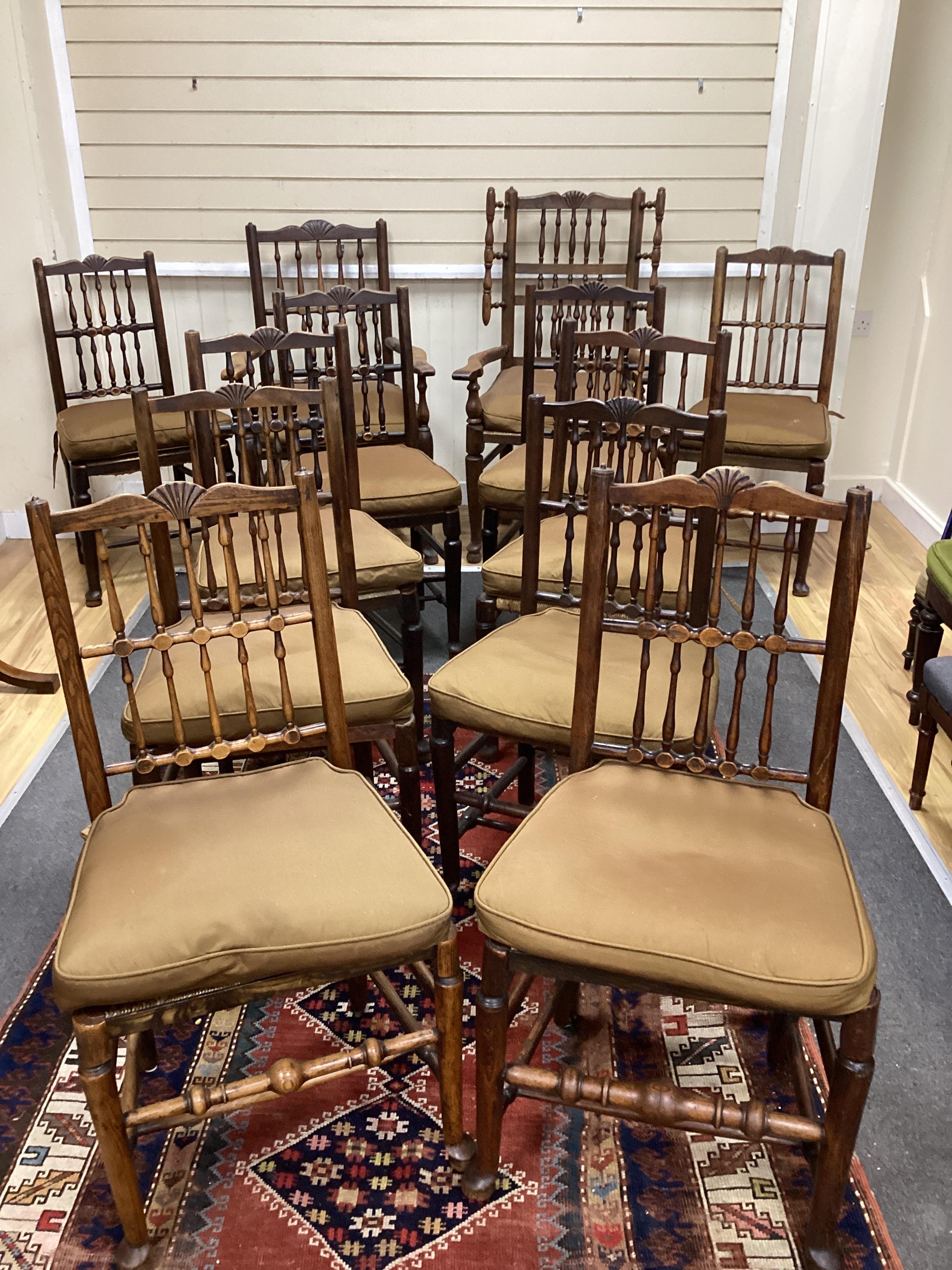 A Harlequin set of twelve 19th century Lancashire ash elm and beech rush seat spindle back chairs with loose cushion squab seats, two with arms